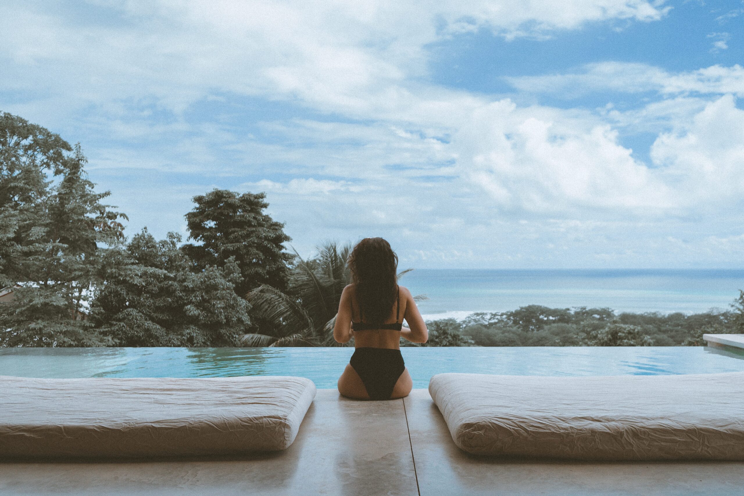 Girl sitting by infinity pool in Costa Rica